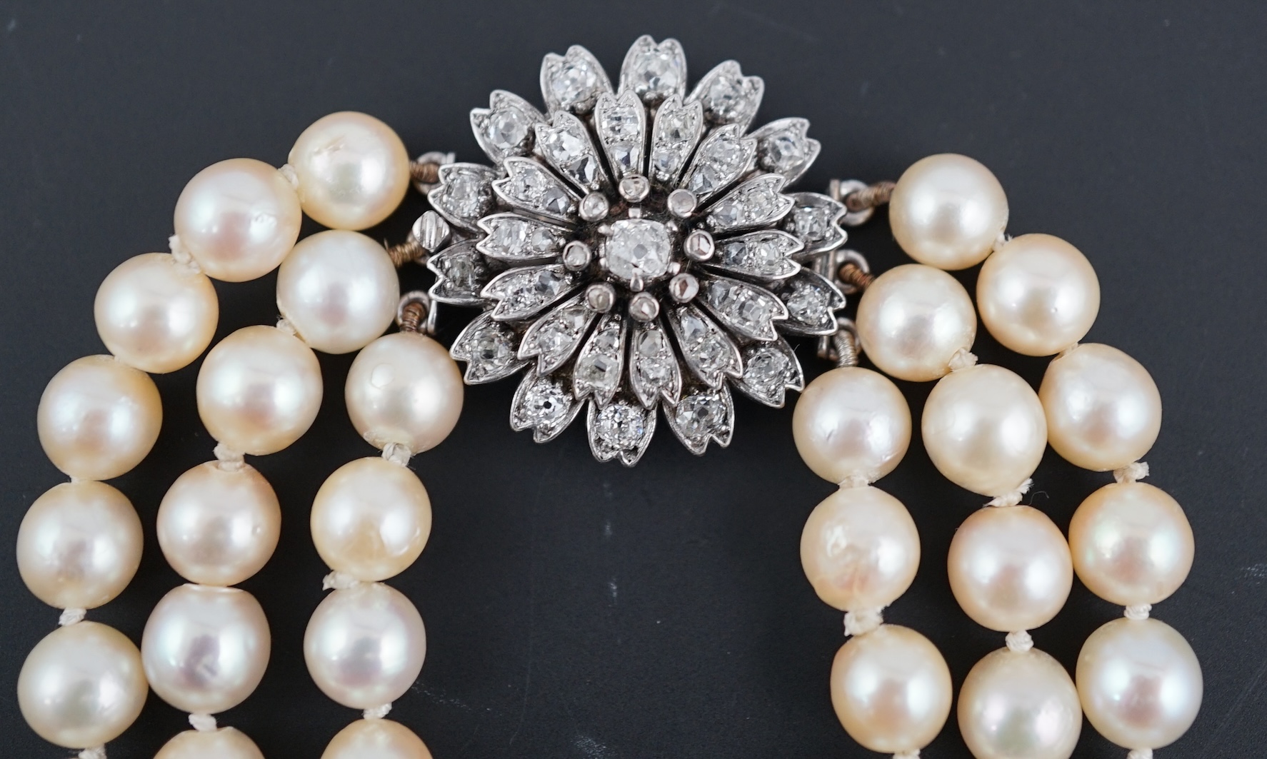 A triple strand graduated cultured pearl choker necklace, with old and rose cut diamond cluster set circular clasp